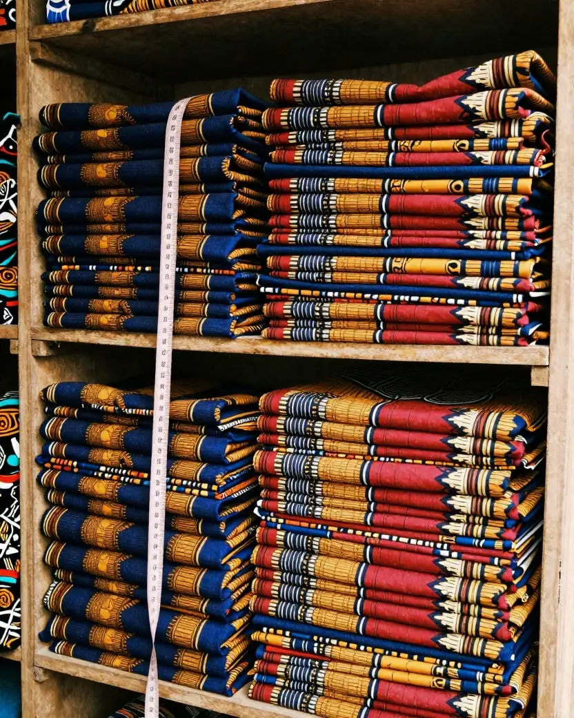 Stacks of folded ankara fabric on shop shelves