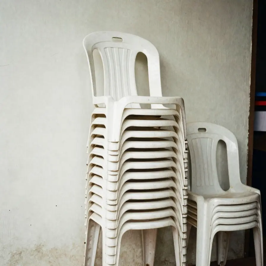A stack of white plastic chairs